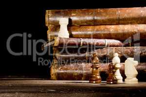 Old books and chess pieces