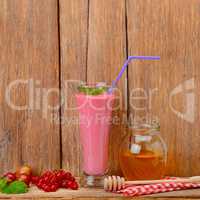 berry smoothie, currants, gooseberries and honey on a wooden sur
