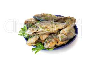 Roasted carp on a plate on a white background.