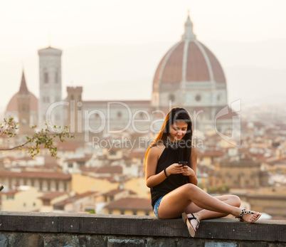 Teen at sunset in Florence uses the smartphone