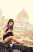 Teen at sunset in Florence uses the smartphone