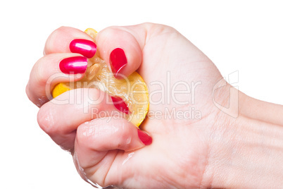 Hand with manicured nails squeeze lemon on white