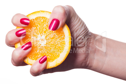 Hand with manicured nails touch an orange on white