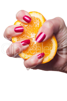 Hand with manicured nails touch an orange on white