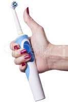 Hand holds electric toothbrush against white