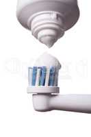 Close up of electric toothbrush and paste on white