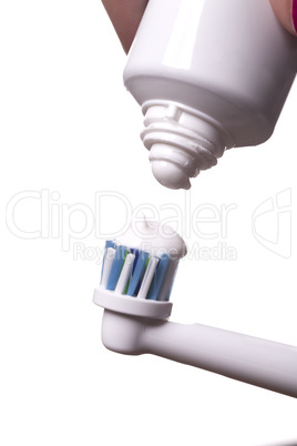 Close up of electric toothbrush and paste on white