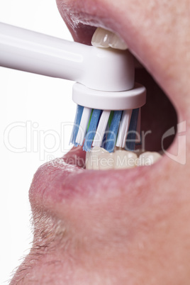 Close up of electric toothbrush and paste on white