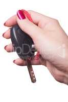 Close up of hand holding car key on white