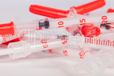 Pile of Empty Syringes with Red Safety Caps