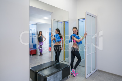 Sexy girls posing in locker room of fitness center