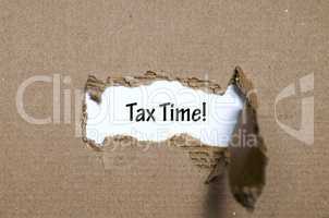 The word  tax time appearing behind torn paper