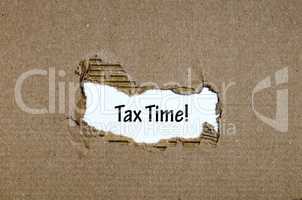The word  tax time appearing behind torn paper