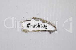 The word hashtag appearing behind torn paper