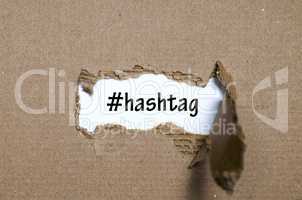 The word hashtag appearing behind torn paper