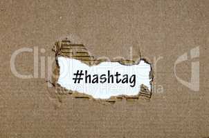 The word hashtag appearing behind torn paper