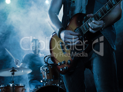 Rock band performs on stage. Guitarist.