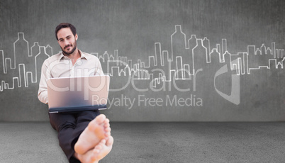 Composite image of smiling man using a laptop