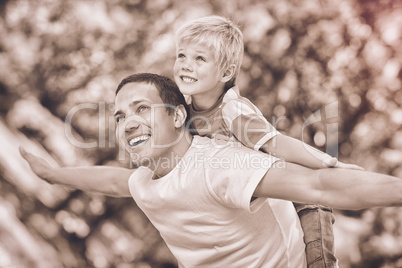 Son playing with his father in the park during the summer