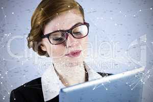 Composite image of redhead businesswoman using her tablet pc