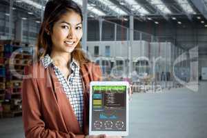 Composite image of smiling businesswoman showing a tablet