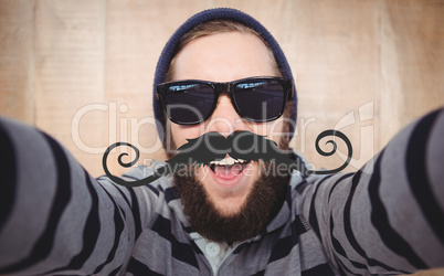 Composite image of portrait of happy hipster wearing sunglasses