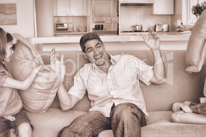 Family having pillow fight on sofa