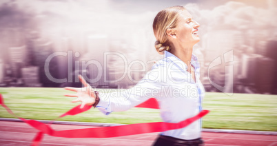 Composite image of successful businesswoman raising arms