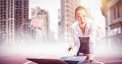 Composite image of businesswoman on knees holding a laptop