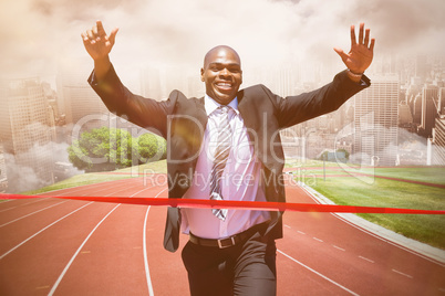 Composite image of businessman crossing the finish line