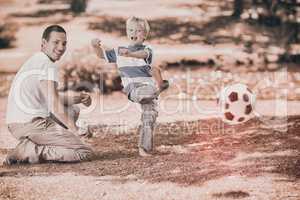 Father playing football with his son during the summer