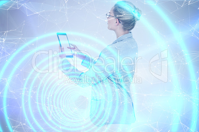 Composite image of businesswoman using a tablet