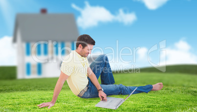 Composite image of smiling man using a laptop