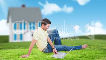 Composite image of smiling man using a laptop