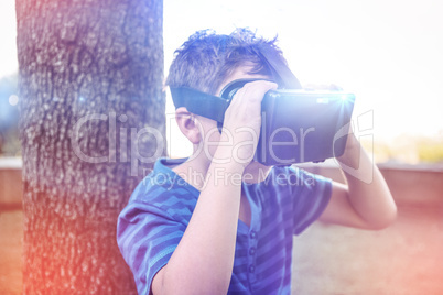 Elementary boy looking through virtual reality headset in school