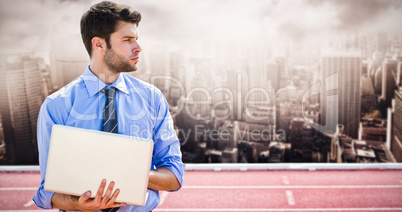 Composite image of businessman using a laptop