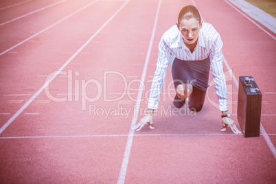 Composite image of concentrate woman in starting blocks