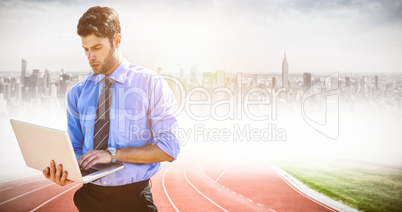 Composite image of businessman using a laptop