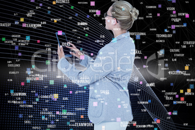 Composite image of businesswoman using a tablet