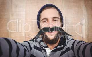 Composite image of portrait of happy hipster with hooded shirt