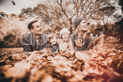 Smiling young family throwing leaves around