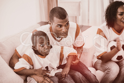Happy family watching a football match
