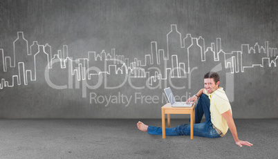 Composite image of smiling man using a laptop