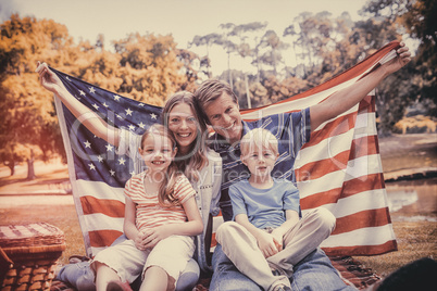 Hapy family holding american flag in the park