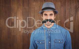 Composite image of portrait of happy hipster wearing hat