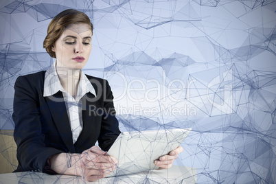 Composite image of redhead businesswoman using her tablet pc