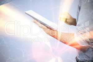 Composite image of businessman using digital tablet over white b