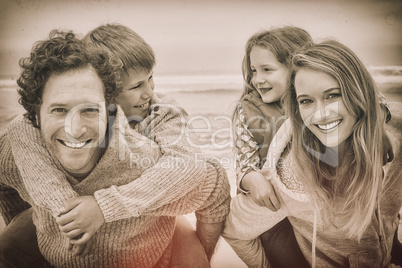 Happy couple piggybacking kids at beach