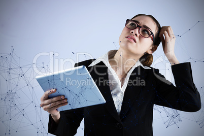 Composite image of thinking businesswoman looking at tablet pc