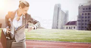 Composite image of businesswoman looking at her watch
